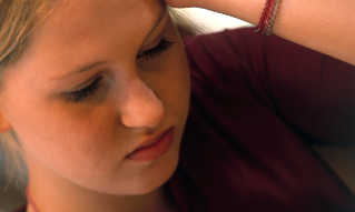 Teenage girl with hand on head